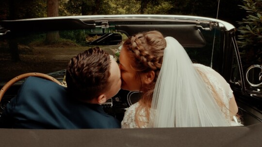 Trouwfilm Eerbeek - Kus in trouwauto - Cinemora.